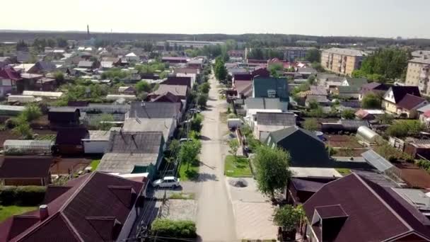 Vista superior da estrada em linha reta na aldeia com casas. Imagens de stock. Cidade industrial velha com casas particulares no fundo da floresta e horizonte — Vídeo de Stock