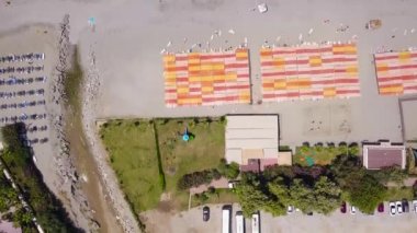 Deniz ve rıhtımın turkuaz dalgalarıyla sahilin en üst manzarası. Stok görüntüleri. Güneşli ve dalgalı güneşli bir sahil beldesi. Deniz kenarında yaz tatili