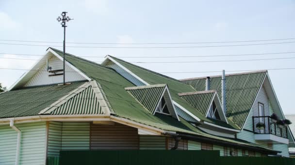 Revêtement de toit vert. Images d'archives. Belle toiture verte est faite de planchers profilés. Nouvelle couverture de toit de maison de campagne. Toit à plusieurs versants avec fenêtres sur les côtés — Video