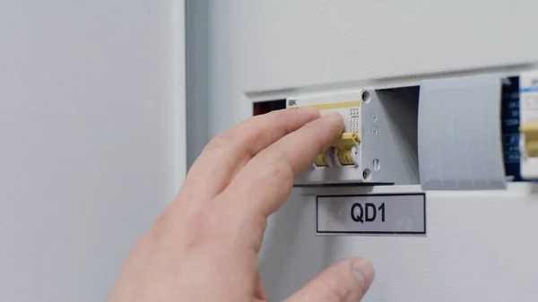 Close up of the man hand switching off and on automatic fuse, electric equipment concept. Stock footage. Male hand switching on and off the light in a box with automatic fuses.