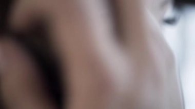 Esmer kadının elini kulağının arkasına itip gümüş bir küpe taktığı yakın plan. Başla. Siyah saçlarına dokunan bir kızın yan görüntüsü..