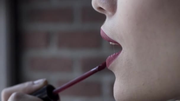 Side view portrait of a sexy woman model with bright lips makeup and healthy shiny skin, beauty concept. Action. Close up of beautiful woman putting on lipstick and making a kissing gesture. — Stock Video