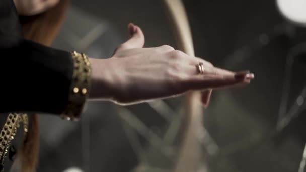 Close-up van vrouwelijke drummer handen houden drumstick op donkere repetitieruimte achtergrond. Actie. Vrouwelijke muzikant hand houden en spinnen houten drumstick. — Stockvideo