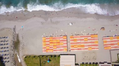 Deniz ve rıhtımın turkuaz dalgalarıyla sahilin en üst manzarası. Stok görüntüleri. Güneşli ve dalgalı güneşli bir sahil beldesi. Deniz kenarında yaz tatili