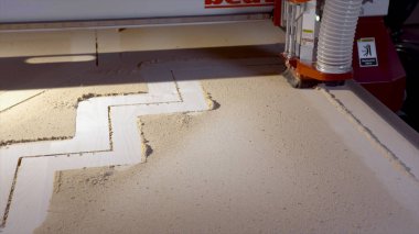 Fabrika makinesinin tahta kesimine yakın plan. Başla. Otomatik makine verilen yörüngelere kalın kontrplak kesiyor