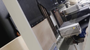 Tahta tahtada delik açan otomatikleştirilmiş makinelere yakın çekim. Başla. Ahşap ürünlerin işlenmesi için endüstriyel girişimde tahta tahtalarda delikler açan makine