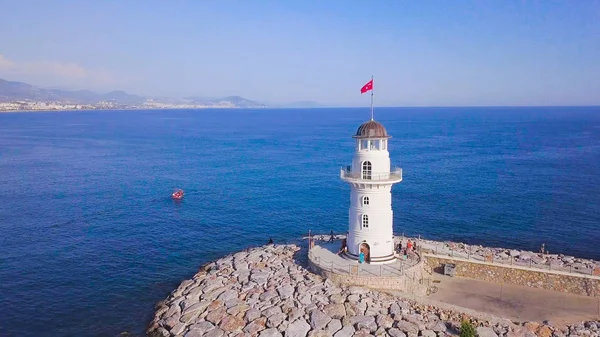 Deniz manzaralı deniz feneri ve sahil şehri. Şarjör. Güzel deniz manzaralı tatil köyü açıklarında beyaz deniz feneri