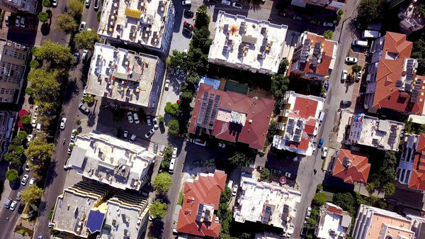 Top view of roofs of high-rise residential buildings in city center. Clip. In center of southern resort town houses roofs and moving cars on roads.