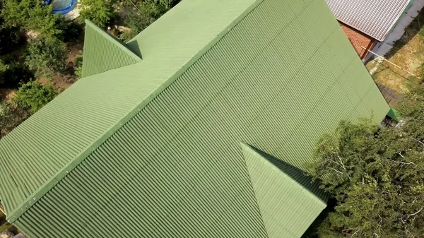 Cubriendo el techo verde de la casa de pueblo. Imágenes de archivo. Vista superior del techo perfilado techo verde de la casa. Nuevo techo verde de la casa de pueblo en verano —  Fotos de Stock