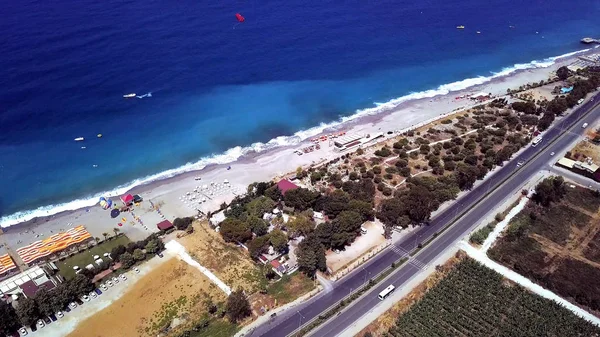 Blick von oben auf den Stadtstrand mit schönem blauen Meerwasser. Archivmaterial. Autobahn verläuft entlang Küste in der Nähe von Strand und blauem Wasser des Ozeans. großartiger Ort für den Sommerurlaub am Meer — Stockfoto