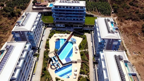 Vista superior de la moderna ciudad agrícola en las montañas. Imágenes de archivo. Hermosa ciudad sureña situada en una zona montañosa con hoteles y campos agrícolas —  Fotos de Stock