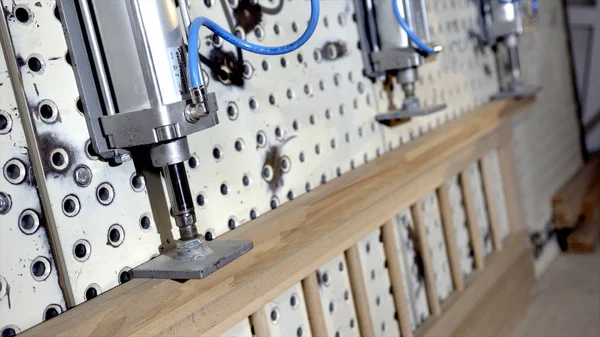 Close-up of furniture pressing machine. Action. Process of pressing modern machine in industrial enterprise. Creation of wooden furniture at stage of joining parts on pressing machine