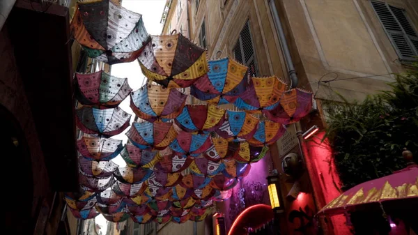 Pendaison de parasols colorés. L'action. Vue du bas de vieux parasols suspendus sur la rue de la ville. Parapluies suspendus décorant les rues de vieux fiers — Photo