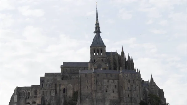 Mont Saint Michel, Normandy France, architecture concept. Action. Medieval abbey on the mountain of the same name on cloudy sky background. — Stock Photo, Image