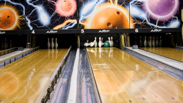 Los bolos vuelan a los lados de una pelota. Medios. Bola de bolos rompe los pines —  Fotos de Stock