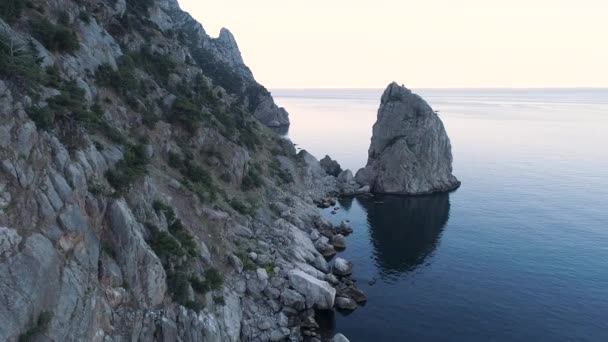 Vista aerea di fantastiche grandi rocce e calme increspature oceaniche al tramonto. Gli hanno sparato. Splendido paesaggio naturale dell'acqua blu dell'oceano vicino a enormi scogliere ripide . — Video Stock