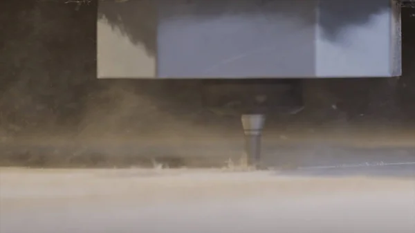 Close-up de madeira de corte em uma fresadora CNC com aparas de madeira voando para os lados. Acção. Máquina com controle numérico de corte de viga de madeira . — Fotografia de Stock