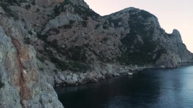 Taşlı sahil yakınlarındaki güzel renkli büyük uçurum ve denizin havadan panoramik manzarası. Vuruldu. Uçsuz bucaksız kayaların yanında nefes kesici derin mavi deniz, yaz mevsimi deniz manzarası..