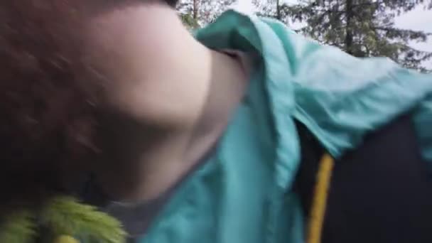 Blízký záběr turisty míjejícího kameru a dotýkajícího se borovicové větve za ramenem v lese. Akciová stopa. Vousatý muž v kulatých brýlích procházející lesem, turistický koncept. — Stock video
