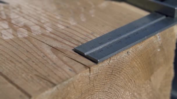 Close up of measurement and marking of a wooden beam with a pencil. Clip. Carpenter in white gloves making marks on wooden bar with pencil and angle ruler, house building process. — Stock Video