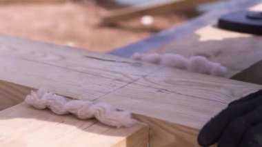 Ahşap ev iskeleti inşa edilirken insan eli ahşap kirişe çarpar. Şarjör. Marangoz çekiçle tahta parmaklıkları çekiçliyor..