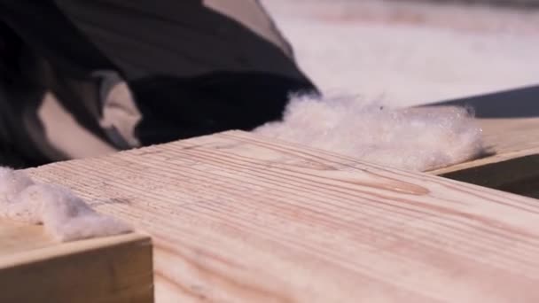 Primer plano de carpintero masculino en guantes uniformes y blancos martillando viga de madera mientras se construyen encofrados. Clip. Hombre trabajador golpeando anchas barras de madera con un mazo . — Vídeo de stock