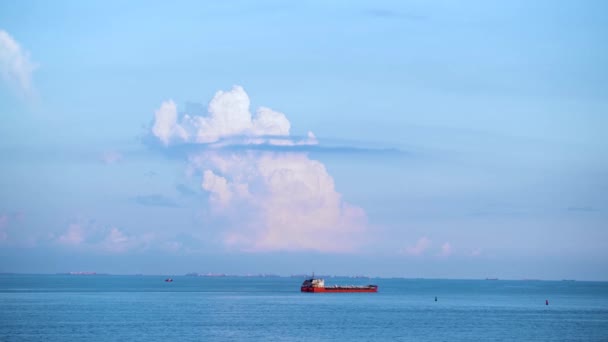 Breathtaking seascpe with a sailing red barge on blue cloudy sky on the background, water transport concept. Shot. Cargo ship barge on the sea horizon in a summer sunny day. — Stock Video