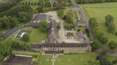 Avrupa 'nın gri kır evlerinin havadan görünüşü, bulutlu yaz gününde yeşil ağaçlarla çevrili yüzme havuzlu park yeri ve arsa. Başla. Güzel kır manzarası