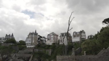 Yazın yamacın tepesinde gri bulutlu gökyüzüne karşı duran muhteşem, modaya uygun kulübelere en alttan bakın. Başla. Güzel Avrupa mimarisi