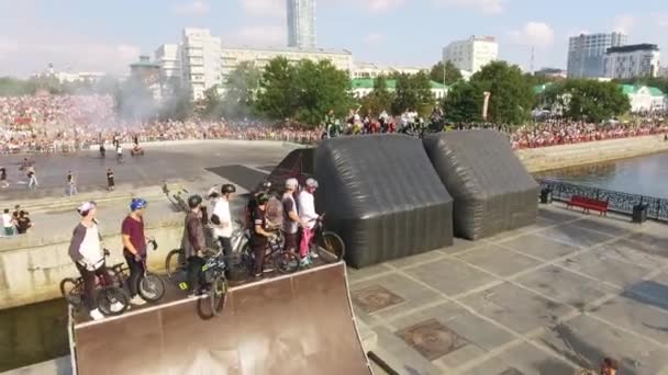 Vue rapprochée des champions de compétition de vélo et de moto freestyle debout sur les rampes, souriant et agitant les mains. L'action. Les gens au Bike Fest — Video