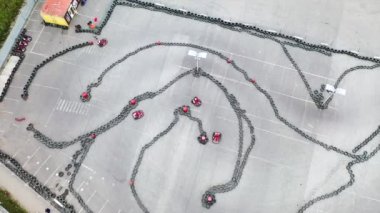 Yarışçılar karting pistinde koruyucu üniforma, miğfer ve hava görüşüyle yarışıyorlar. Medya. Kart sürüş eğitimi. Kart yarışı