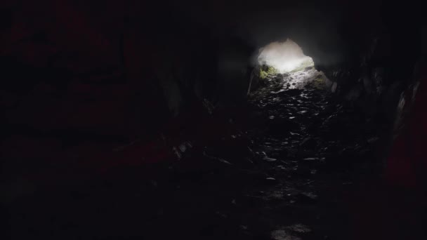 Lumière passant à travers un trou éclairant une mystérieuse grotte sombre. Images d'archives. Vue à l'intérieur d'un très vieux tunnel mystique à travers la roche de montagne . — Video