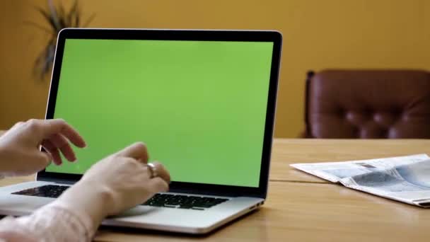 Green laptop screen and female hands typing. Stock footage. Elegant hands of woman typing on laptop with green screen. Close-up of woman working on laptop typing articles — Stock Video