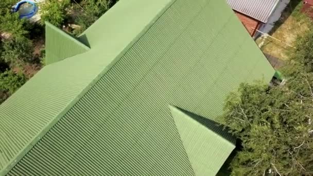 Cubriendo el techo verde de la casa de pueblo. Imágenes de archivo. Vista superior del techo perfilado techo verde de la casa. Nuevo techo verde de la casa de pueblo en verano — Vídeo de stock