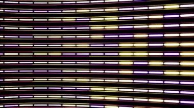 Soyut neon çizgilerin yatay akışı mor ve sarı renklerde ve kamera lensleri siyah arkaplanda bükülmüş. Animasyon. Dar çizgiler bölümlere ayrılmış, dikişsiz döngü.