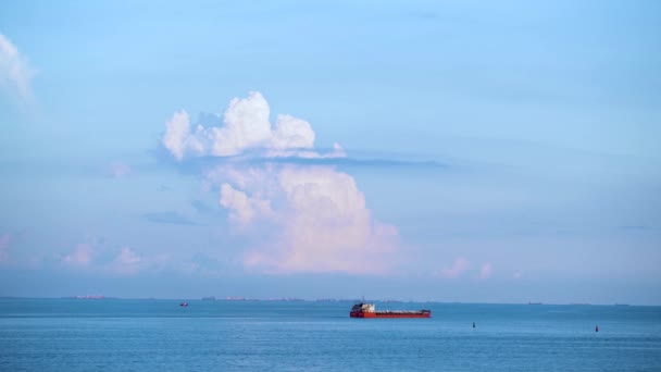 Cargo container ship sailing in still frozen summer sea on blue cloudy sky background. Shot. Red barge floating in blue sea on skyline background. — Stock Video