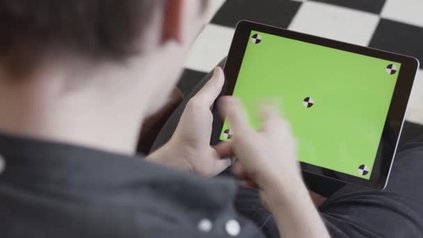 Buisnessman εμφάνιση μιας πράσινης οθόνης tablet στην πίσω όψη κατά τη χρήση gatget. Στικ. Επιχειρηματίας που εργάζεται στο σπίτι σε tablet και για την αειφόρο ανάπτυξη του έργου — Αρχείο Βίντεο