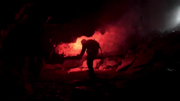 Hombre geólogo con una llamarada de señal roja explorando cueva oscura subterránea, concepto de ciencia. Imágenes de archivo. Científico tratando de encontrar una manera de salir de la cueva . — Vídeos de Stock