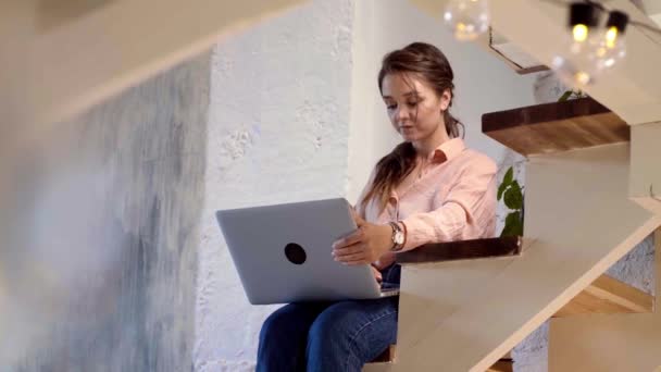 Menina usando seu laptop em sua casa. Imagens de stock. Jovem mulher trabalhando no laptop em casa — Vídeo de Stock