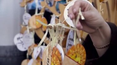 Kapalı kadın eli, sokaktaki tahta bir çubuğa yazılı bir dilekle bir not asıyor. Şarjör. Geleneksel bir dilek tutup notu ağaç dalına bırakmak adettendir..