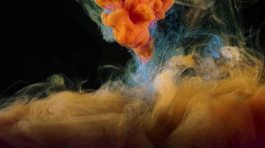 Sudaki renkli boyaların akışına yakın çekim. Stok görüntüleri. Makro fotoğrafçılık, siyah arkaplanda suda güzel renkli mürekkep sıçraması.
