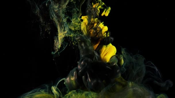 Αργή κίνηση ανάμειξης χρωμάτων στο νερό. Στικ. Κίτρινο και μαύρο μελάνι αργά σαν καπνός στο νερό σε μαύρο φόντο. Όμορφο μελάνι στο νερό για screensaver φόντο — Αρχείο Βίντεο