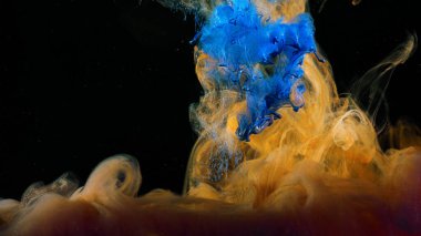 Sudaki renkli boyaların akışına yakın çekim. Stok görüntüleri. Siyah zemin üzerinde suda güzel renkli mürekkep sıçraması makrosu