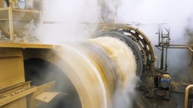 Dönüş cevheri dolgu değirmenini kapatın. Stok görüntüleri. Endüstriyel arka plan, çalışan makineleri ve yükselen buharı olan bir fabrikanın atölyesinin görüntüsü.