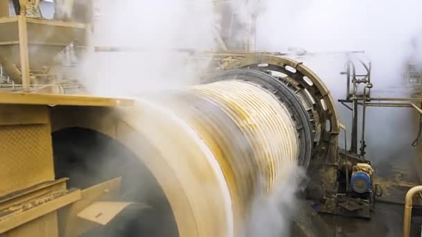 Close up of spinning ore dressing mill. Stock footage. Industrial background, view inside of a workshop of a factory with working machinery and rising steam. — Stock Video