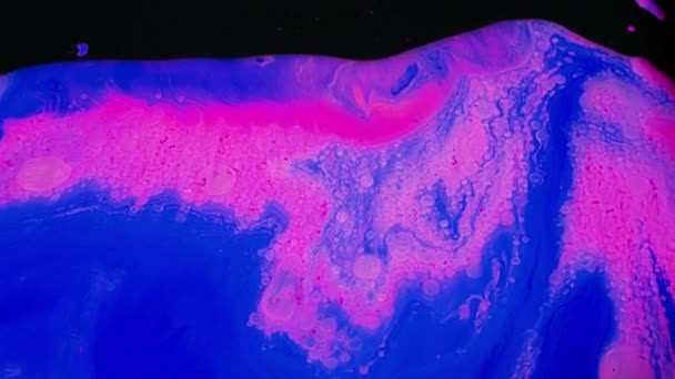 Beautiful mixing of blue and pink colors. Stock footage. Artistic background with mixing in stream of bright colors on black surface. Fluid art — Stock Video