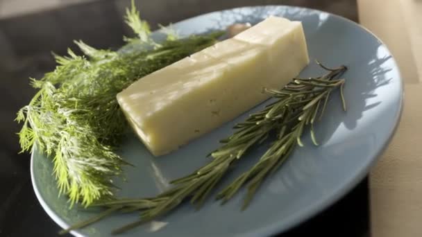 ガラス板にチーズと緑のアップを閉じます。ストック映像だ。新鮮な緑のディルとローズマリーとおいしいチーズ,食品やフランス料理のコンセプト. — ストック動画