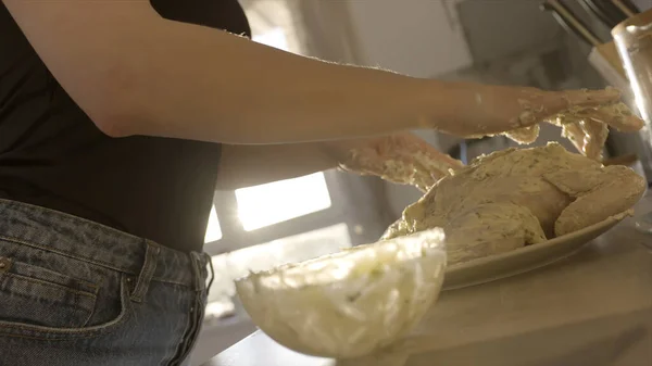 Närbild av kvinnliga händer förbereda kyckling för bakning. Lagerbilder. Kvinnliga händer sätta vit dressing med majonnäs och grönaktig på rå kyckling i köket hemma, begreppet matlagning. — Stockfoto