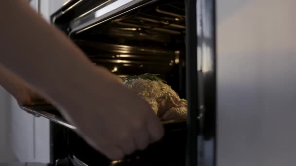 Cocine poniendo pollo crudo con aderezo de mayonesa blanca al horno. Imágenes de archivo. Concepto de cocina casera, primer plano de las manos poniendo pollo con romero en el horno . — Vídeo de stock