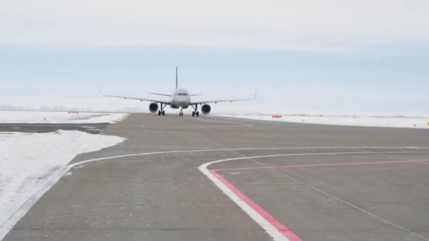 Repülőút a kifutópályán. Készletfelvétel. A gép felszállásra készül a kifutópálya mentén télen. Repülőgép kifutópályán, mielőtt külföldre repülne nyaralni — Stock videók